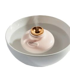 a white bowl with a gold lid and a steam burner in the center, on a white background