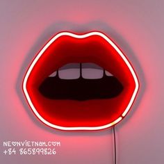 a close up of a neon sign with a person's mouth and tongue on it