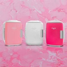 three different colored toasters sitting next to each other on a pink and white background