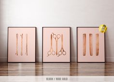 three framed art pieces with scissors and hair clips on them in front of a white wall