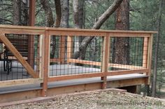 a wooden deck in the woods with metal railings