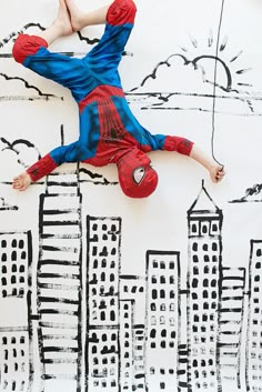 a young boy is upside down on the ground in front of a cityscape