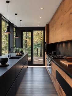 a modern kitchen with wood cabinets and black counter tops, along with an outdoor deck