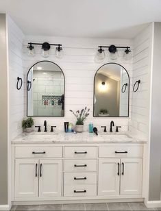 a bathroom with two sinks and mirrors on the wall