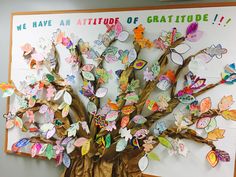 a bulletin board with butterflies on it and a tree made out of leaves in the center