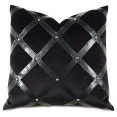 a black and silver pillow with metal studding on the edges, in front of a white background