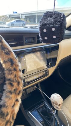 the interior of a car with a stuffed animal in the center console and steering wheel