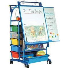 a child's blue easel with lots of toys on it and a white board attached to the back