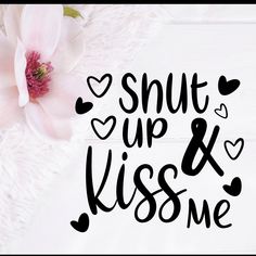 the words shut up and kiss me are next to a flower on a white blanket