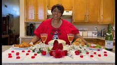 a woman standing in front of a table filled with food and wine glasses on it