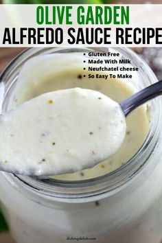 a spoon full of homemade olive garden alfredo sauce in a mason jar with the recipe title above it