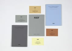 several different colored papers on top of each other with the word hay written in black