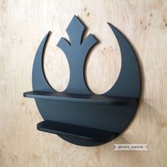 a metal wall hanging on the side of a wooden wall with a star wars symbol