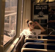 a woman sitting on a train looking out the window