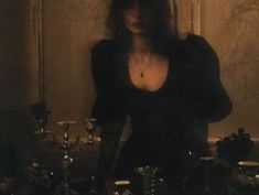 a woman standing in front of a table with candles