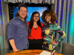 two women and a man standing in front of a table