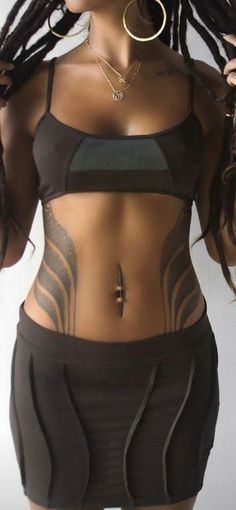 a woman with dreadlocks and tattoos on her body wearing a black bra top