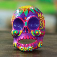 a brightly colored skull sitting on top of a wooden table