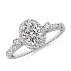 a white gold ring with an oval cut diamond in the center and pave set shoulders