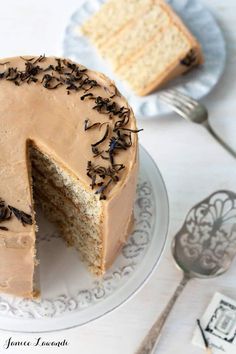 a cake with chocolate frosting and sprinkles on a plate next to a fork