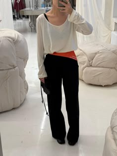 a woman taking a selfie with her cell phone in a room full of mattresses