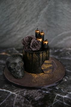 there is a cake with candles on it and a skull next to it that says happy birthday