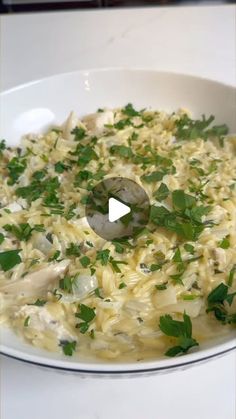 a white bowl filled with food and garnished with parsley on the side