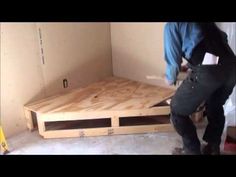 two men working on a wooden floor in a room