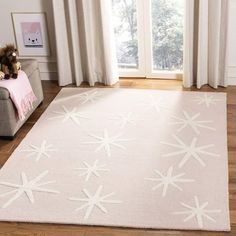 a white rug with stars on it in front of a window and a teddy bear