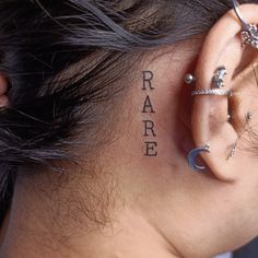 a woman with ear piercings has the word rare written on her side behind her ear