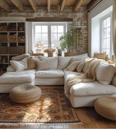 a living room filled with lots of white furniture and pillows on top of a rug