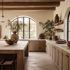 a kitchen filled with lots of counter top space next to a tall vase and potted plant