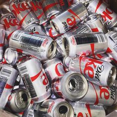 cans of coca - cola are stacked in a bin to be used as gadgets