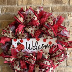 a welcome sign is attached to a red and white mesh wreath with ladybug on it