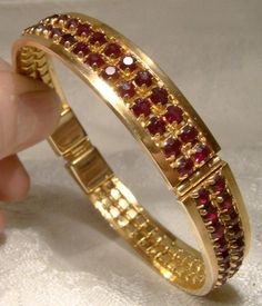 A double row garnet red rhinestone hinged bangle bracelet from the 1960s.  This vintage rigid round gold plated bracelet has an interior measurement of 2-1/2" across and it is 3/8" wide. All of the deep red rhinestones sparkle brilliantly and all are claw-set. The push-in clasp has a red baguette rhinestone.  This well made bracelet is unsigned but of good quality.  Please note that the interior measurement is 2-3/8" at the inner clasp section as the mechanism sits inside the bangle. It is in excellent condition with no chips, cracks, dents, bends, corrosion, losses, damage or repairs. Please note that the rhinestones are a deeper Bohemian garnet red in real life.  Items are vintage or antique and have signs of use and patina as would be expected. Tracked packet to anywhere in the U.S. is Ruby Bangles, Net Design, Bangles Gold, Garnet Red, Bangles Design, Beads Jewellery, Bangles Jewelry Designs, Diamond Jewelry Designs, Gold Bangles Design