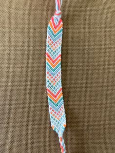 a colorful toothbrush holder on the floor next to a brown carpeted area with an orange, blue, and pink toothbrush