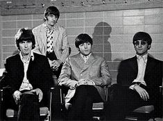 the beatles posing for a black and white photo