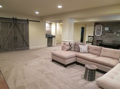 a living room with a sectional couch and sliding barn doors