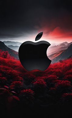 an apple logo in the middle of a field with red trees and mountains behind it