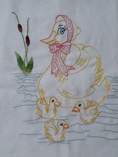 a white towel with a duck and two ducks in the water next to a plant