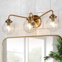 a bathroom vanity light with three bulbs on the side and a mirror in front of it