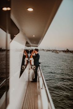 two people are kissing on the back of a boat