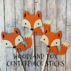 four little fox cupcake toppers on sticks with the words woodland fox centerpiece sticks