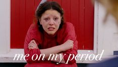 a woman sitting in front of a red door with the words me on my period