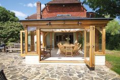 an outdoor dining area with wooden furniture and large glass doors leading to the outside patio