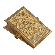 an antique brass box with floral designs on it