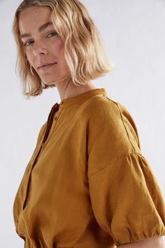 Product Details Puff sleeve top in French linen. The Strom Shirt is a puff sleeve top with a collar stand. The elasticated sleeve cuff is turned over and tacked in four places. The top has a concealed front placket, a bust dart and small side splits at the hem. Crafted from mid-weight French linen, the shirt is durable and breathable, and softens with wear. Puff sleeve top with a collar stand In Peacock, Honey Gold and classic White colourways Elasticated sleeve cuff is turned over and tacked in Australian Dresses, Bust Dart, Regions Of France, Collarless Shirt, French Linen, Plus Size Womens Clothing, Puff Sleeve Top, Classic White, Dart