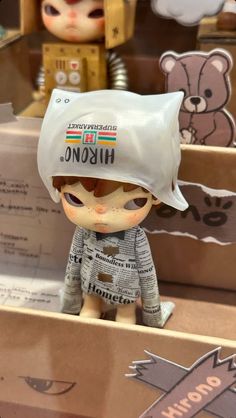 a small doll with a hat on top of it's head sitting in a box