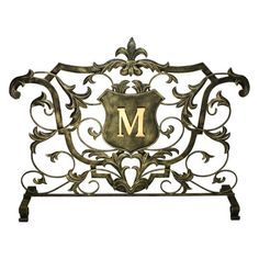 an ornate metal sign with the letter m on it's front and back sides