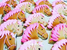 decorated cookies in the shape of horses with pink frosting on them are displayed together